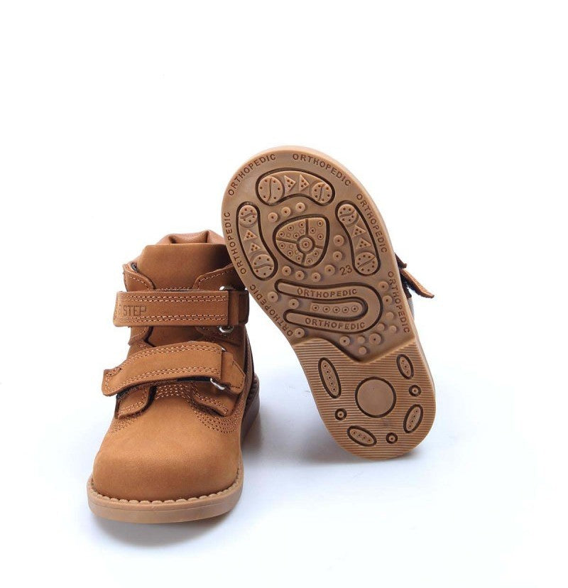 Tan children's boots with a focus on the sole design on a white background