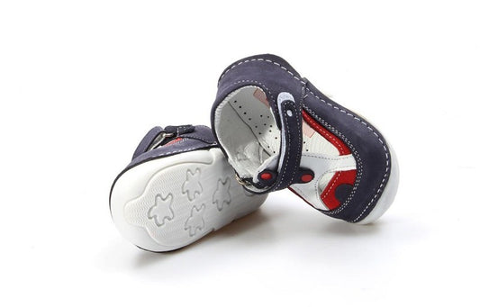 Pair of baby shoes with a white sole and navy and red accents on a white background