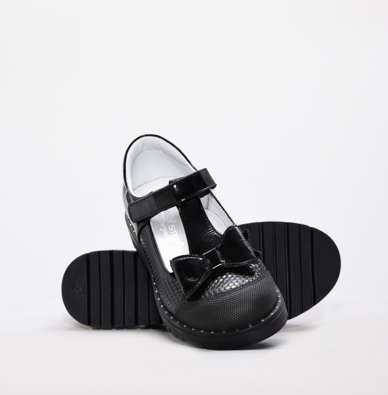 Black school shoes with a bow on a white background