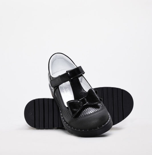 Black school shoes with a bow on a white background